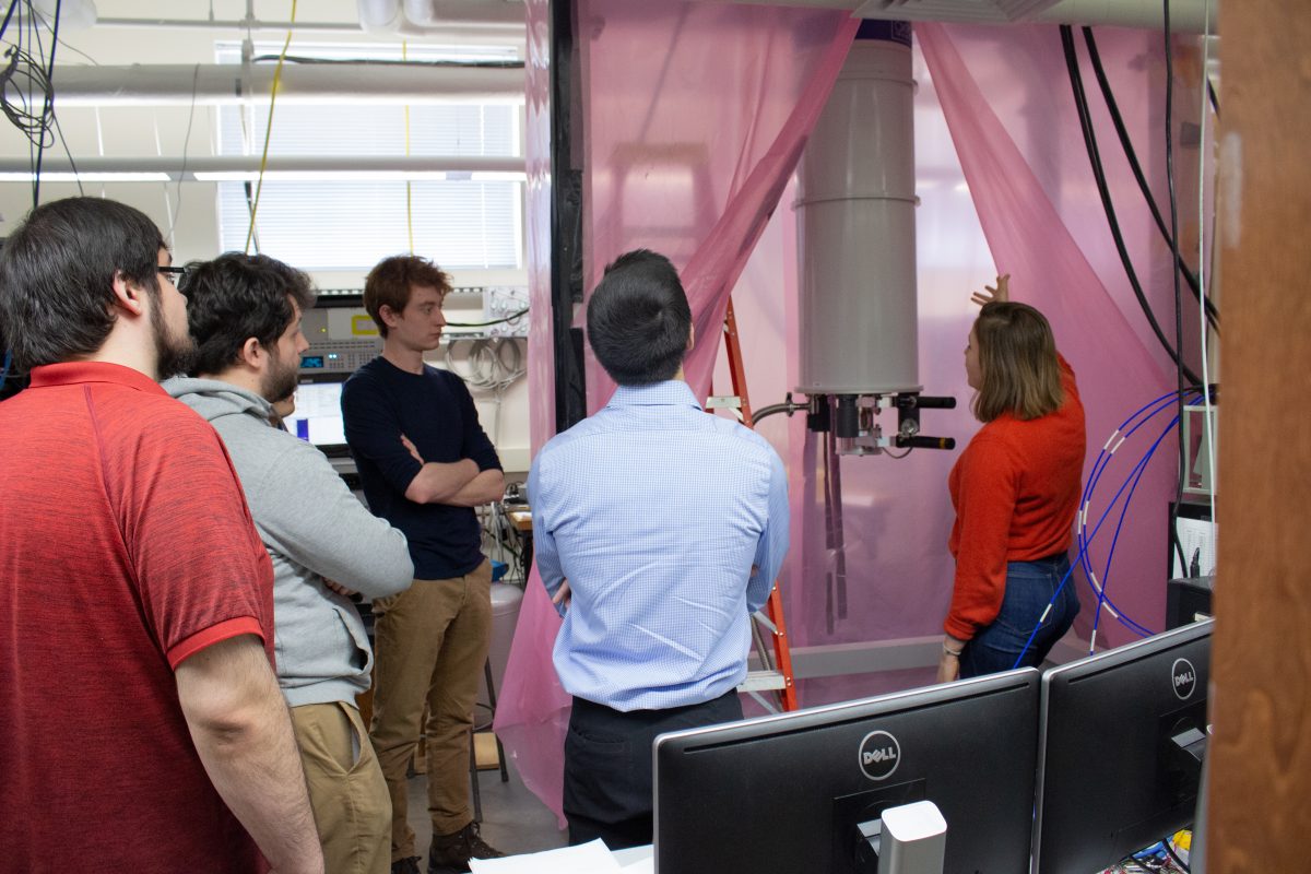 a group of students in a physics lab being shown a quantum computer