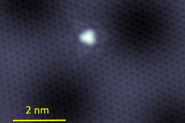a bright white spot is in the center of a dark image, indicating the defect