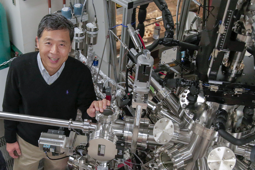 Prof Eom stands in his research lab with lots of metal equiptment