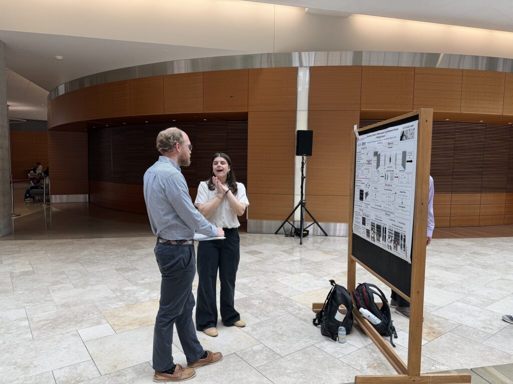 photo of Matt Otten discussing a poster with a student