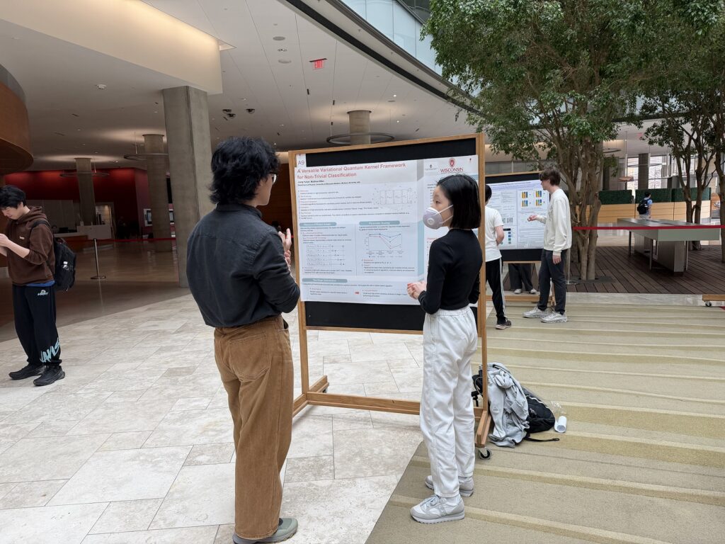 photo of 2 students standing in front of a poster